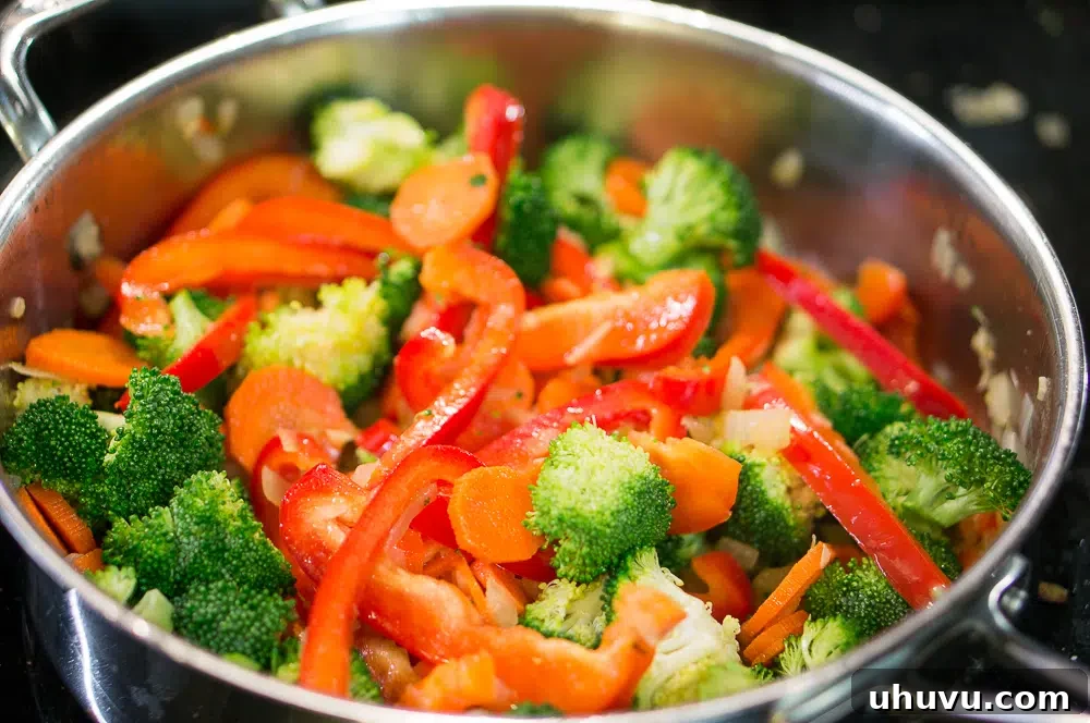 Freshly chopped broccoli, bell pepper, carrots, onion, and garlic ready for sautéing