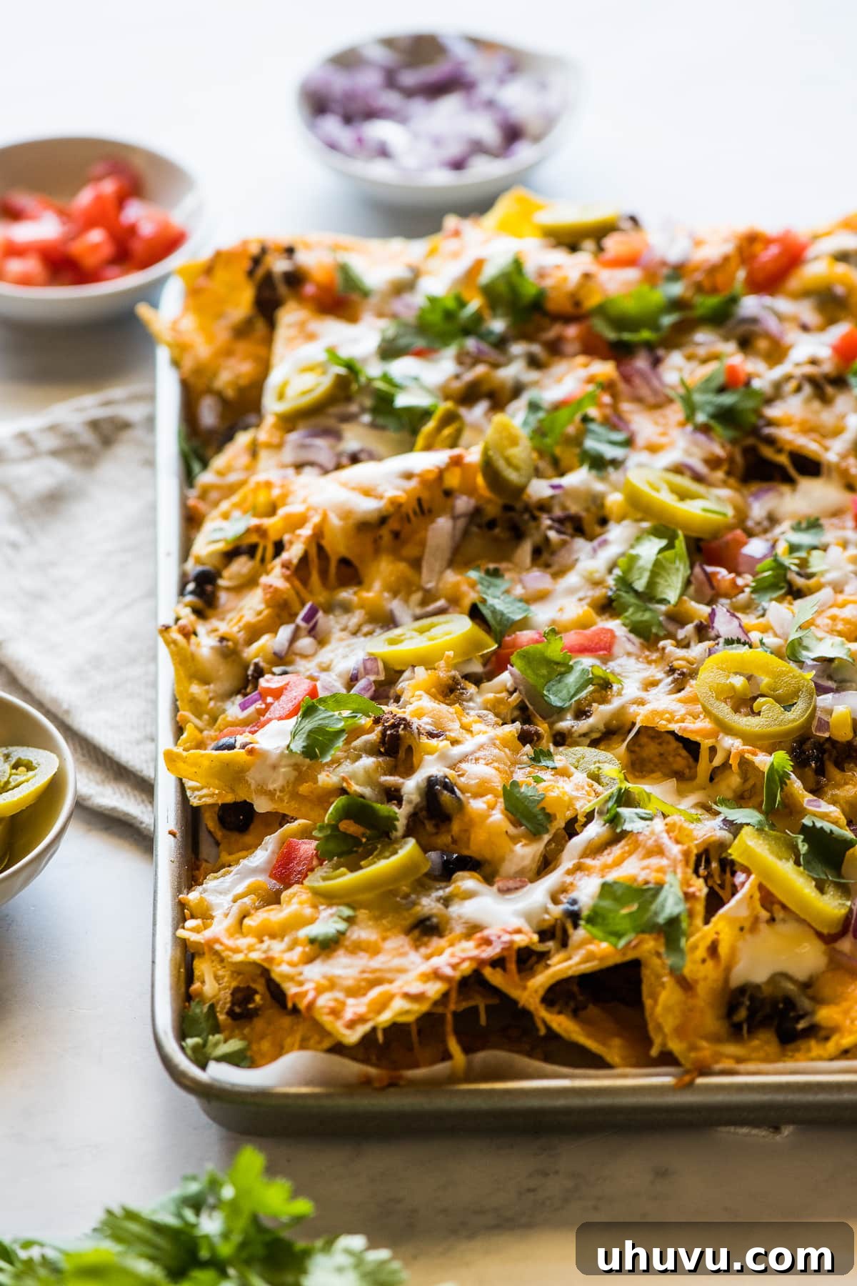 Loaded Sheet Pan Nachos 6 Loaded sheet pan nachos topped with lots of Mexican toppings like sour cream, jalapenos, and cilantro.