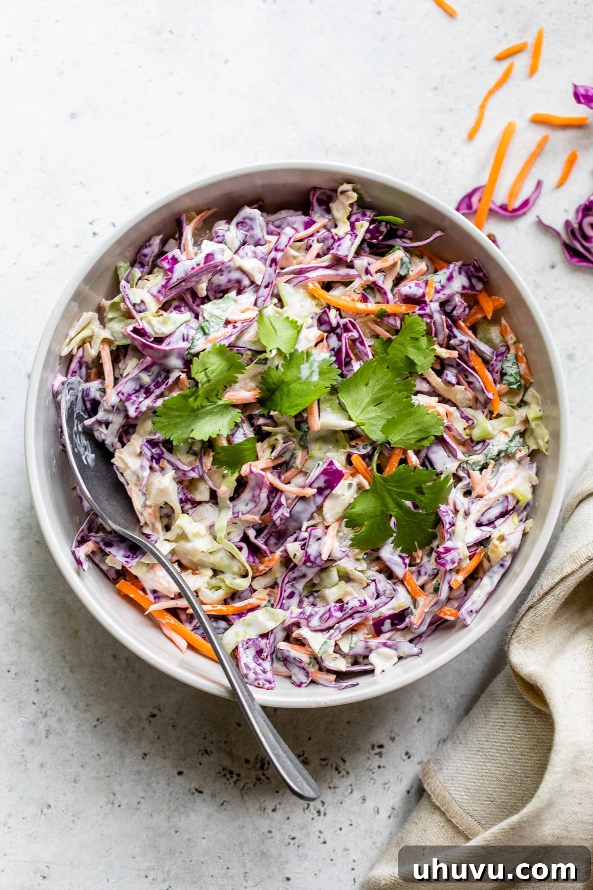 Fish taco slaw in a bowl topped with cilantro leaves.