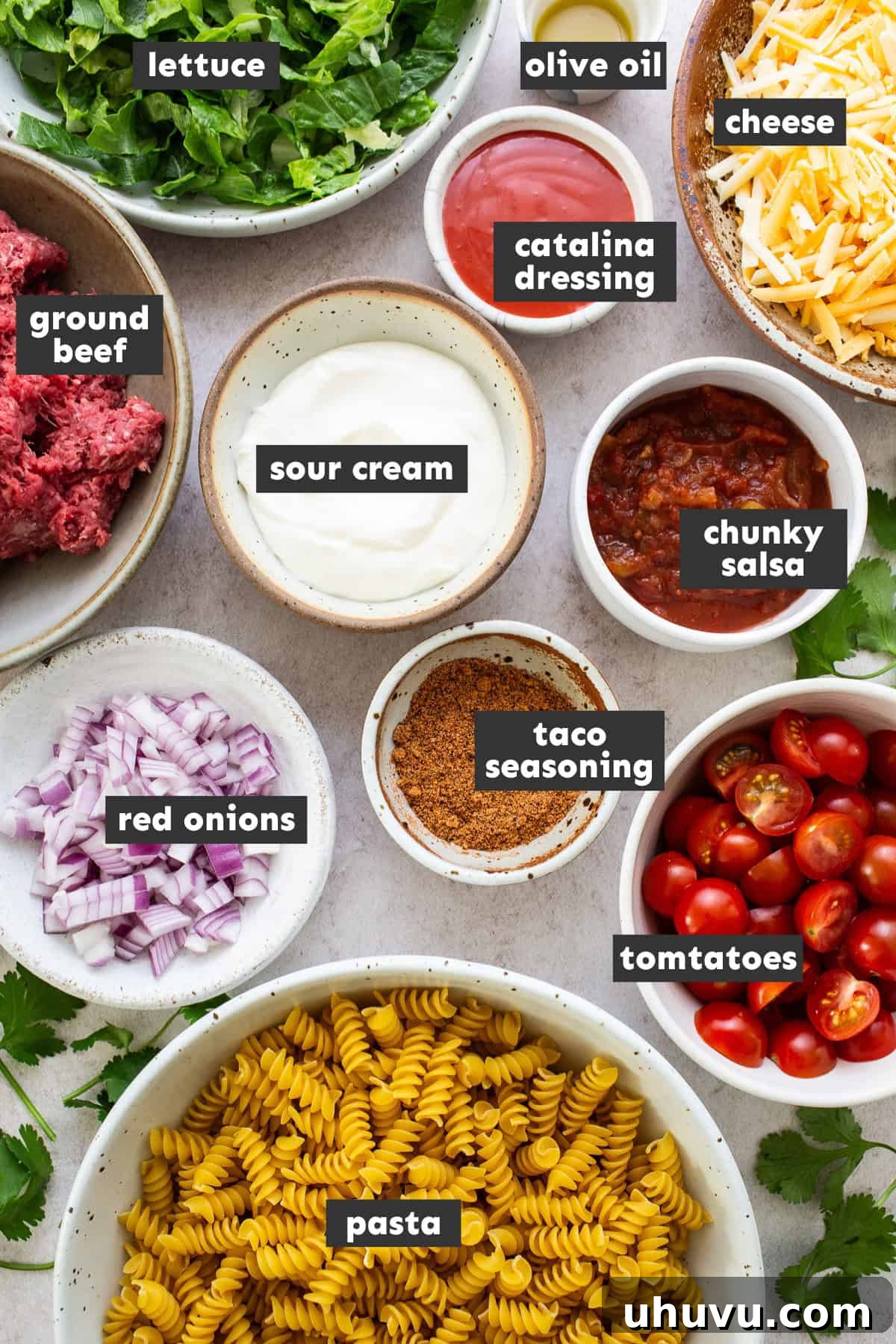 Zesty Taco Pasta Medley 4 All the fresh ingredients for taco pasta salad artfully arranged on a rustic wooden table.