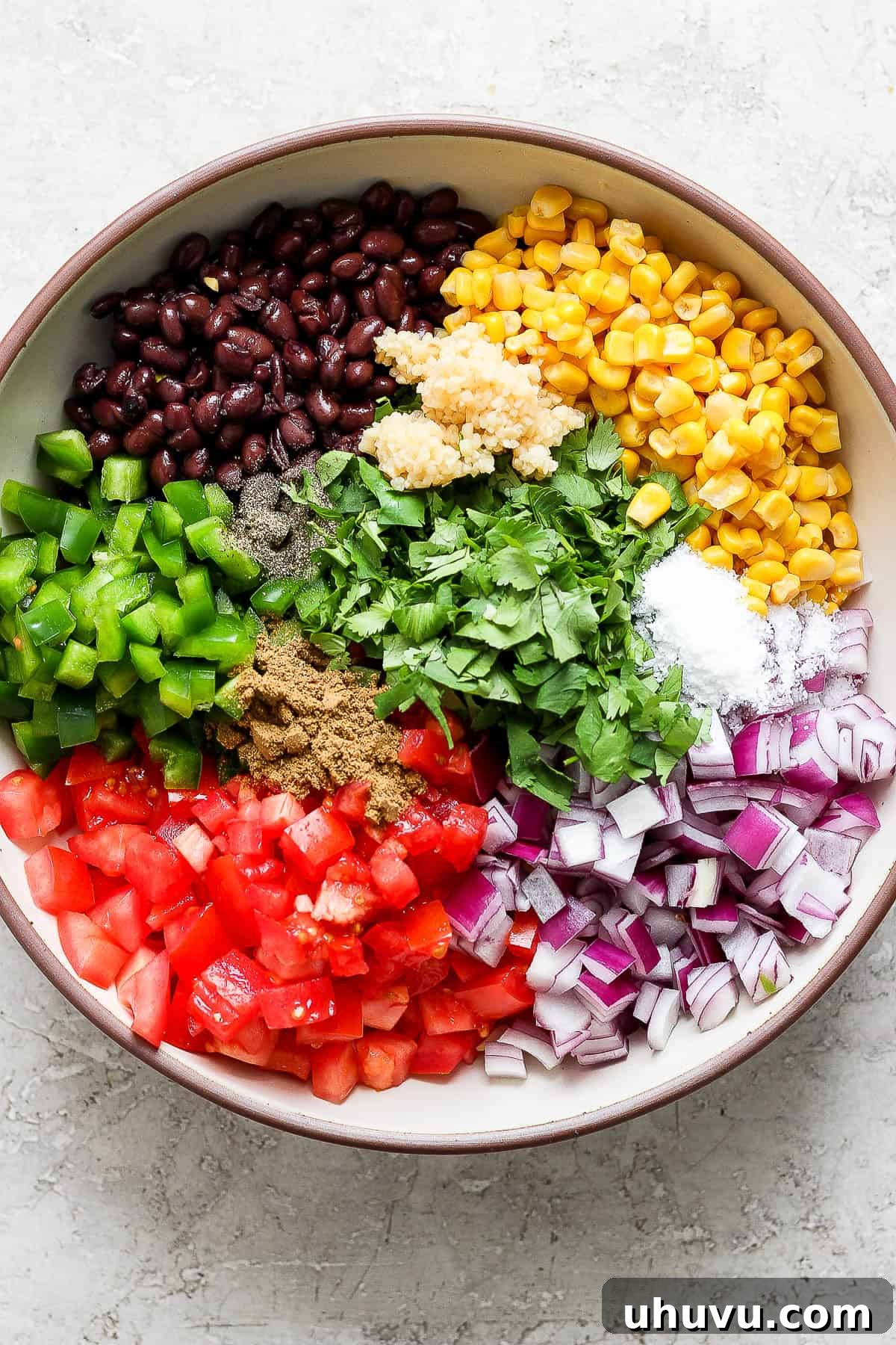 A bowl of ingredients for black bean and corn salsa.