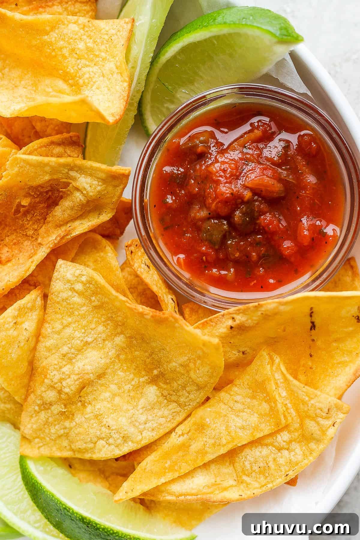 Air fryer tortilla chips with salsa and lime wedges