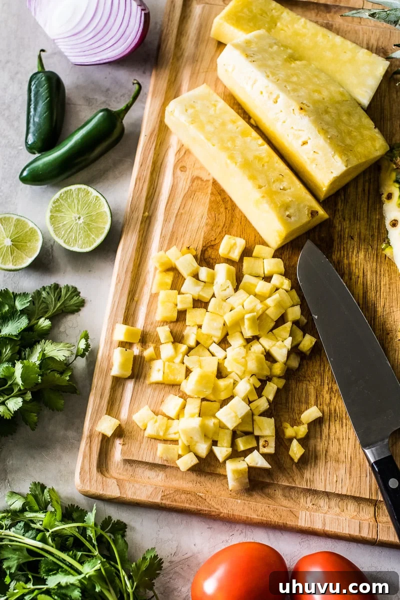 Effortless Pineapple Salsa 3 Diced pineapple on a light wooden cutting board.