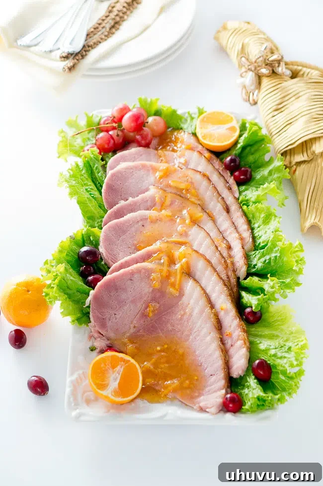 Festive platter with Orange Dijon Glazed Ham, ready for serving guests.