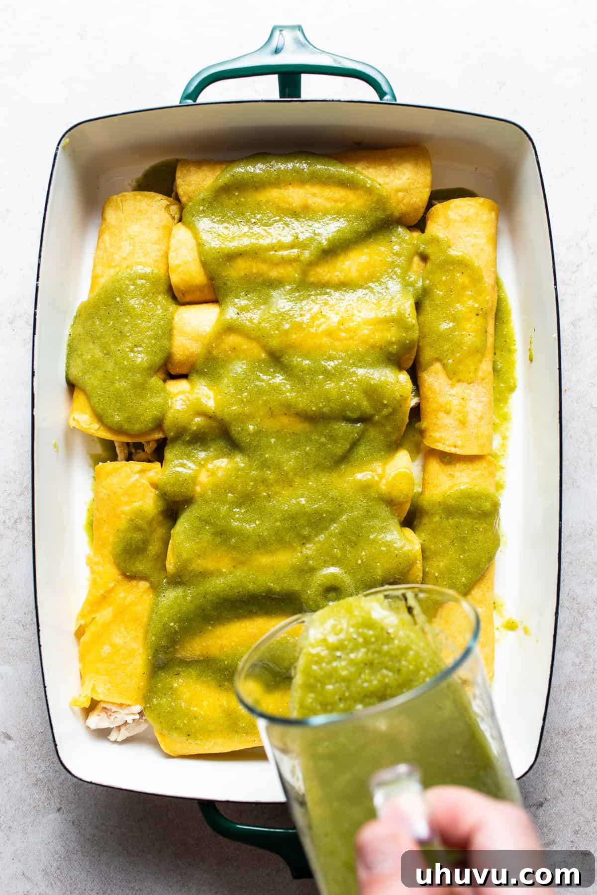 Zesty Green Enchiladas 5 Baking dish with assembled enchiladas covered with salsa verde.