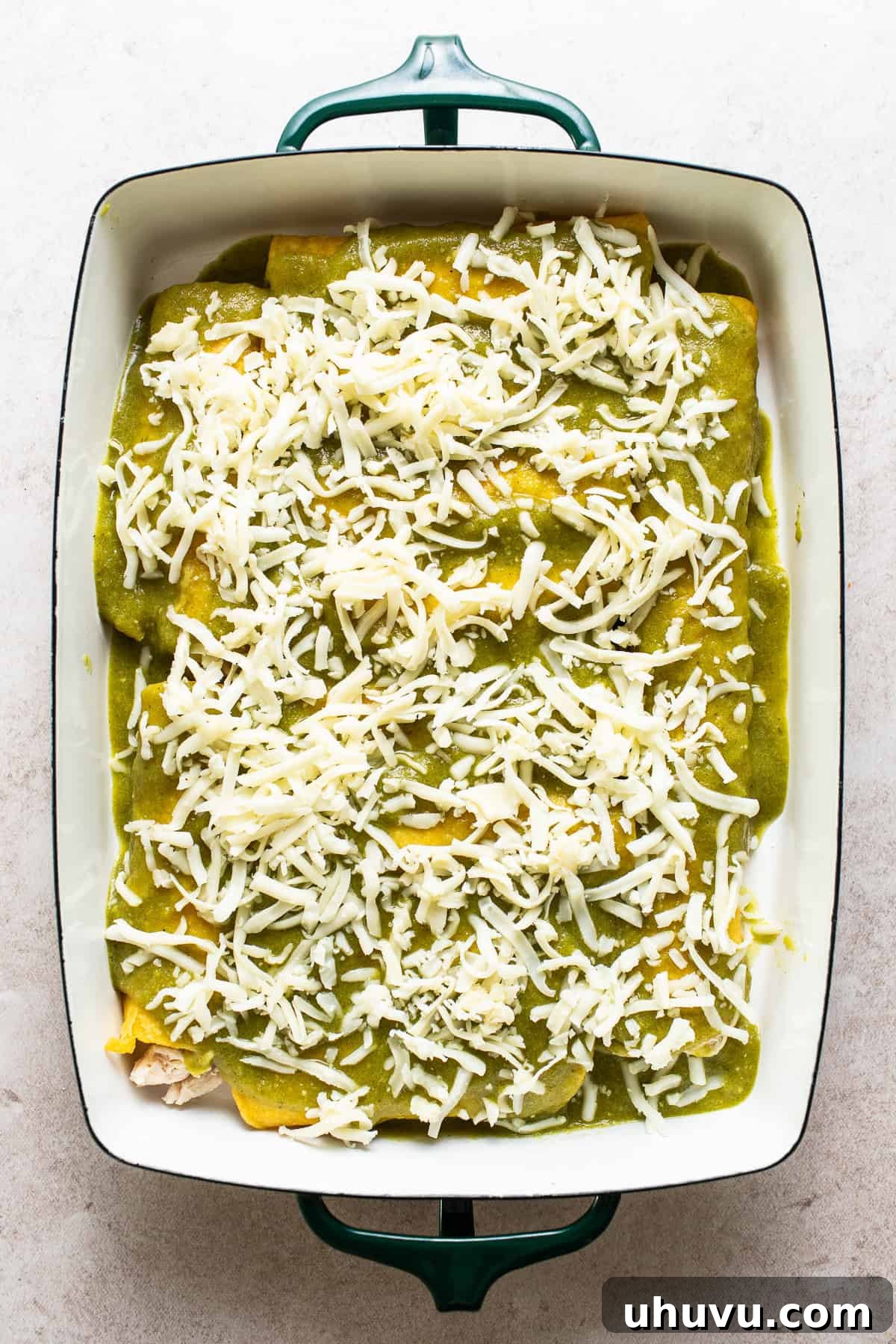 Zesty Green Enchiladas 6 Assembled enchiladas covered with salsa verde and cheese ready to bake.