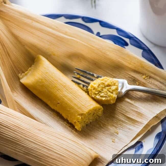 Fresh Corn Tamales 8 A cooked sweet corn tamale on a plate next to a cup of coffee.