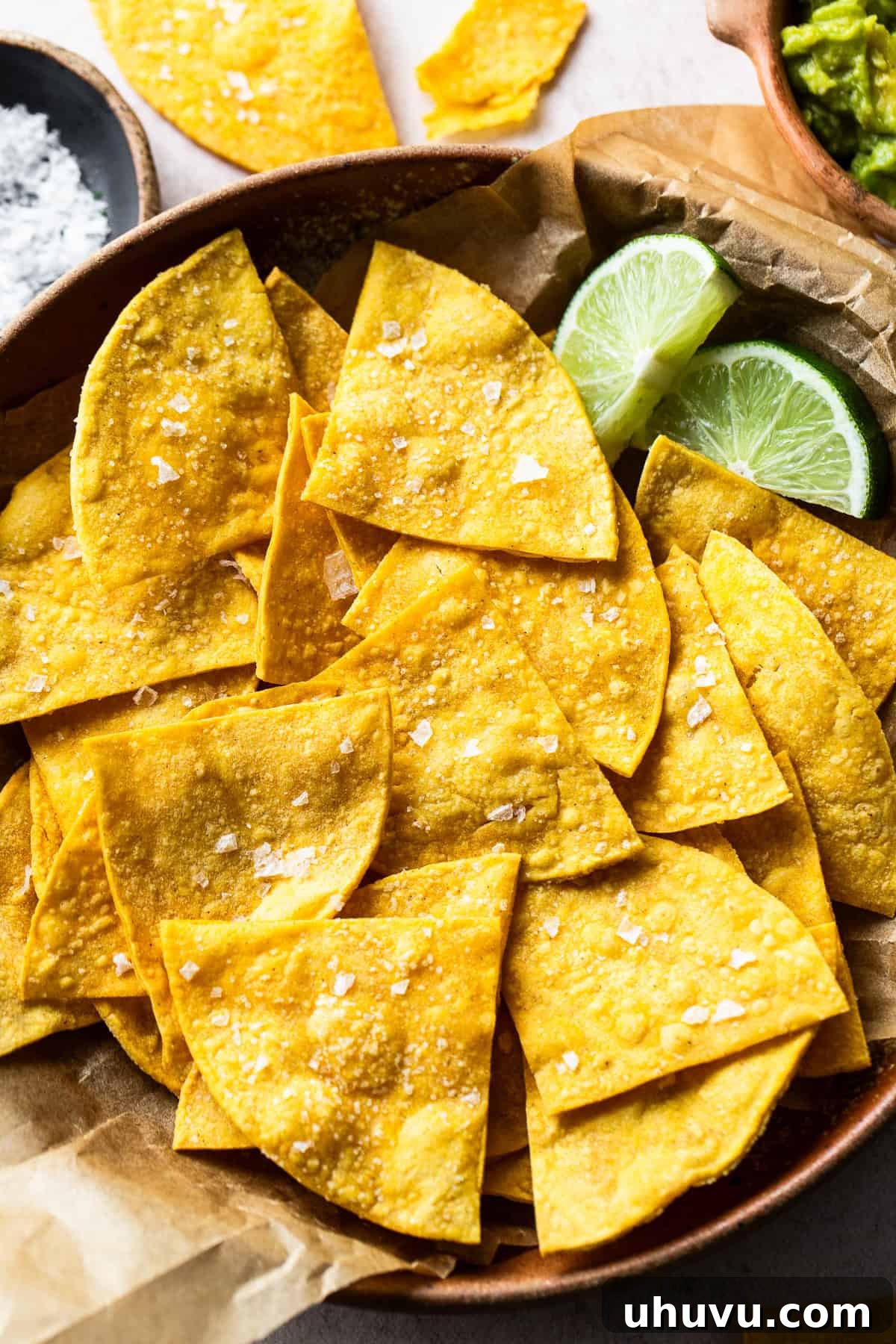 Crispy Oven-Baked Tortilla Chips 2 Baked tortilla chips in a bowl garnished with sea salt, ready to be enjoyed with your favorite dip.