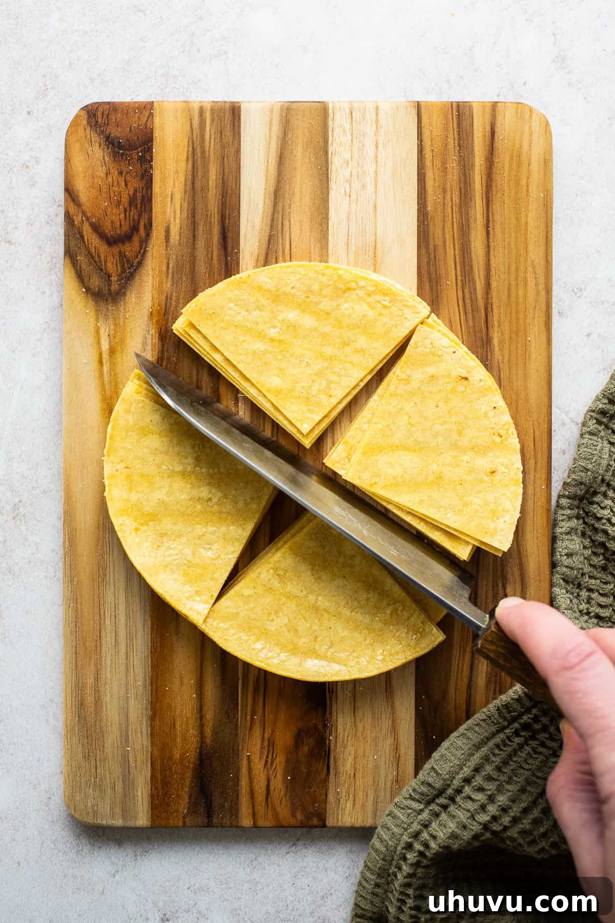 Crispy Oven-Baked Tortilla Chips 5 Corn tortillas being cut into triangle wedges for baked tortilla chips.