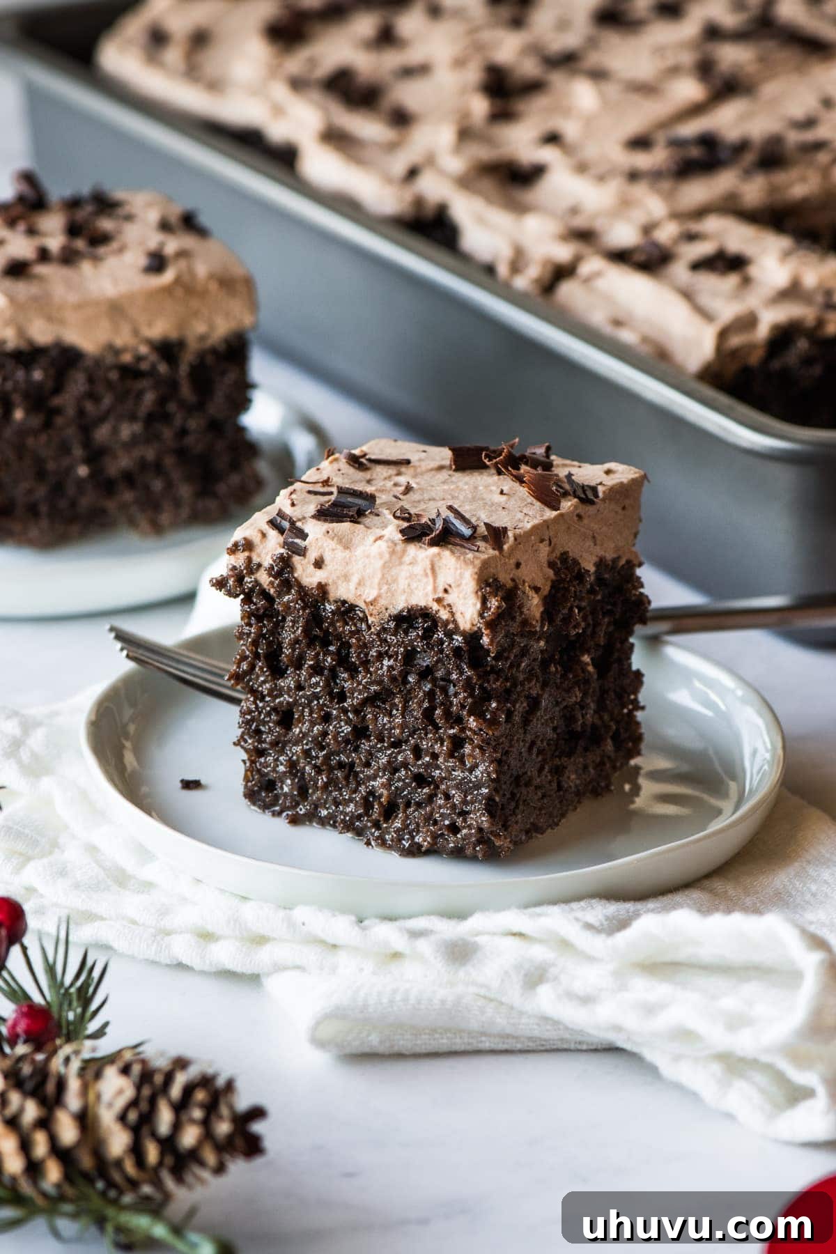 A perfectly sliced piece of moist Chocolate Tres Leches Cake, revealing its rich layers and creamy texture.