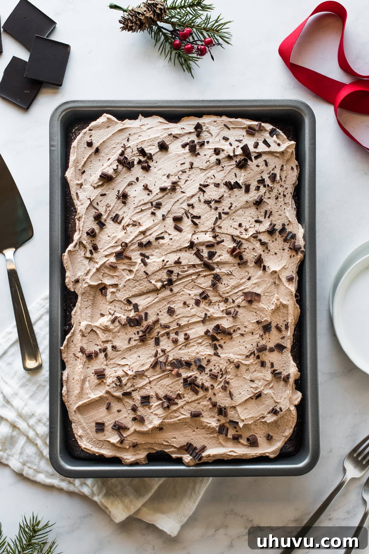 A whole chocolate tres leches cake in a baking dish, generously topped with chocolate shavings.