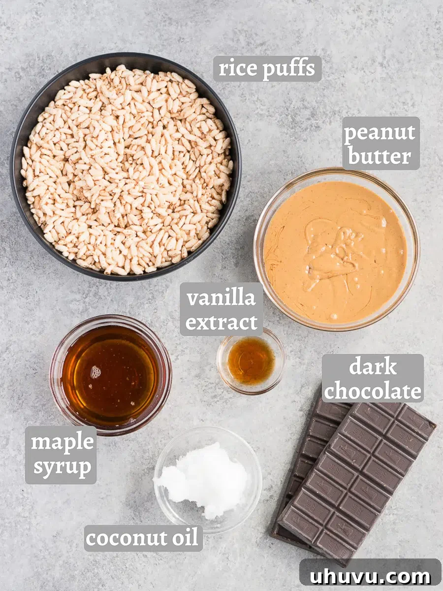 A collection of ingredients for chocolate crunch bars, including chocolate, puffed rice, peanut butter, and maple syrup