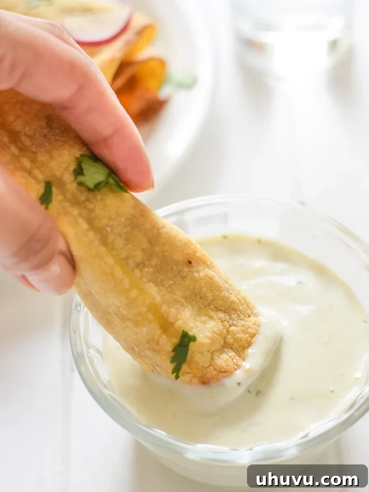 An array of delicious baked chicken, bean, and cheese taquitos, served with a selection of vibrant dipping sauces.