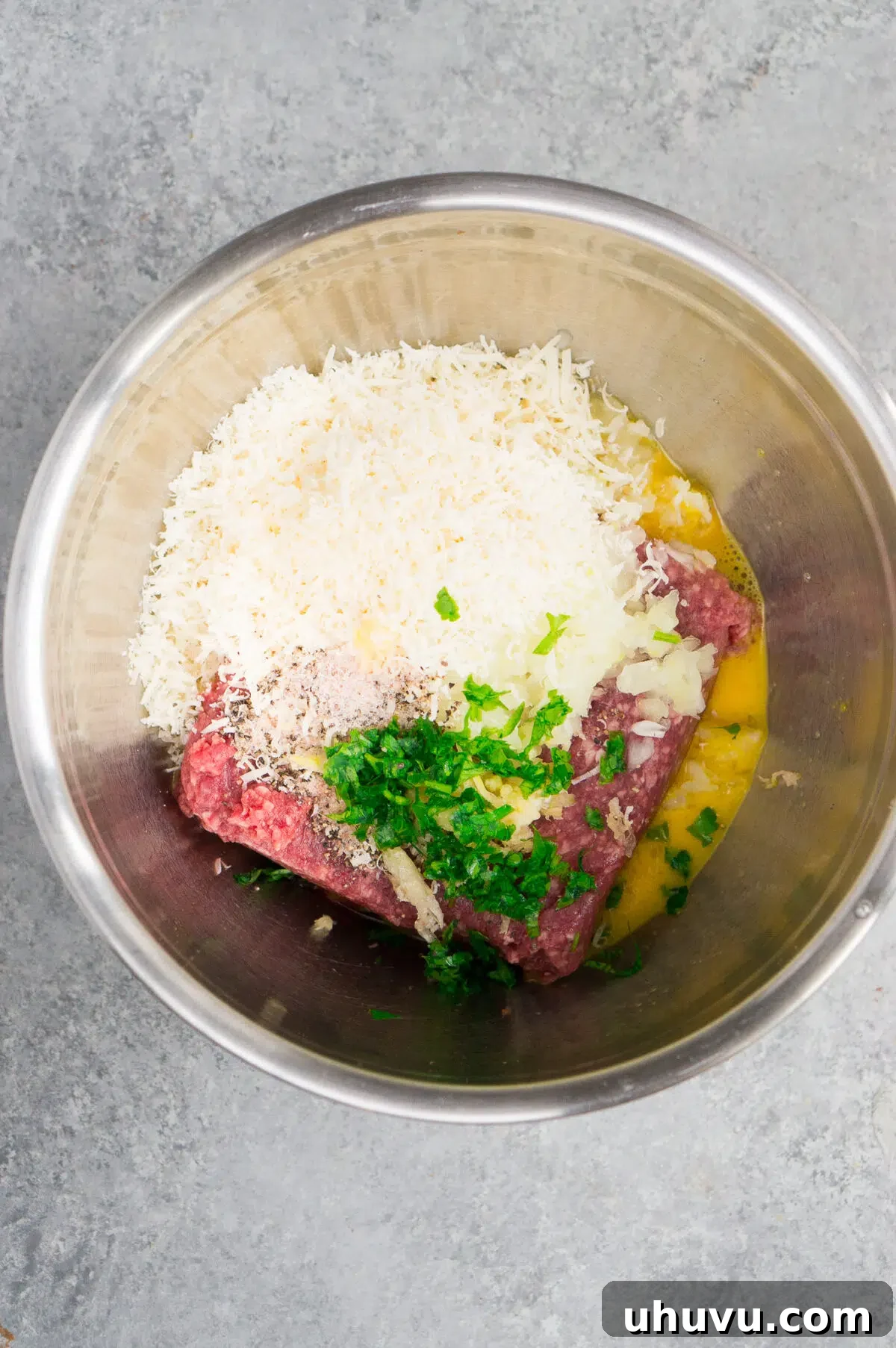 Meatball ingredients combined in a bowl before mixing
