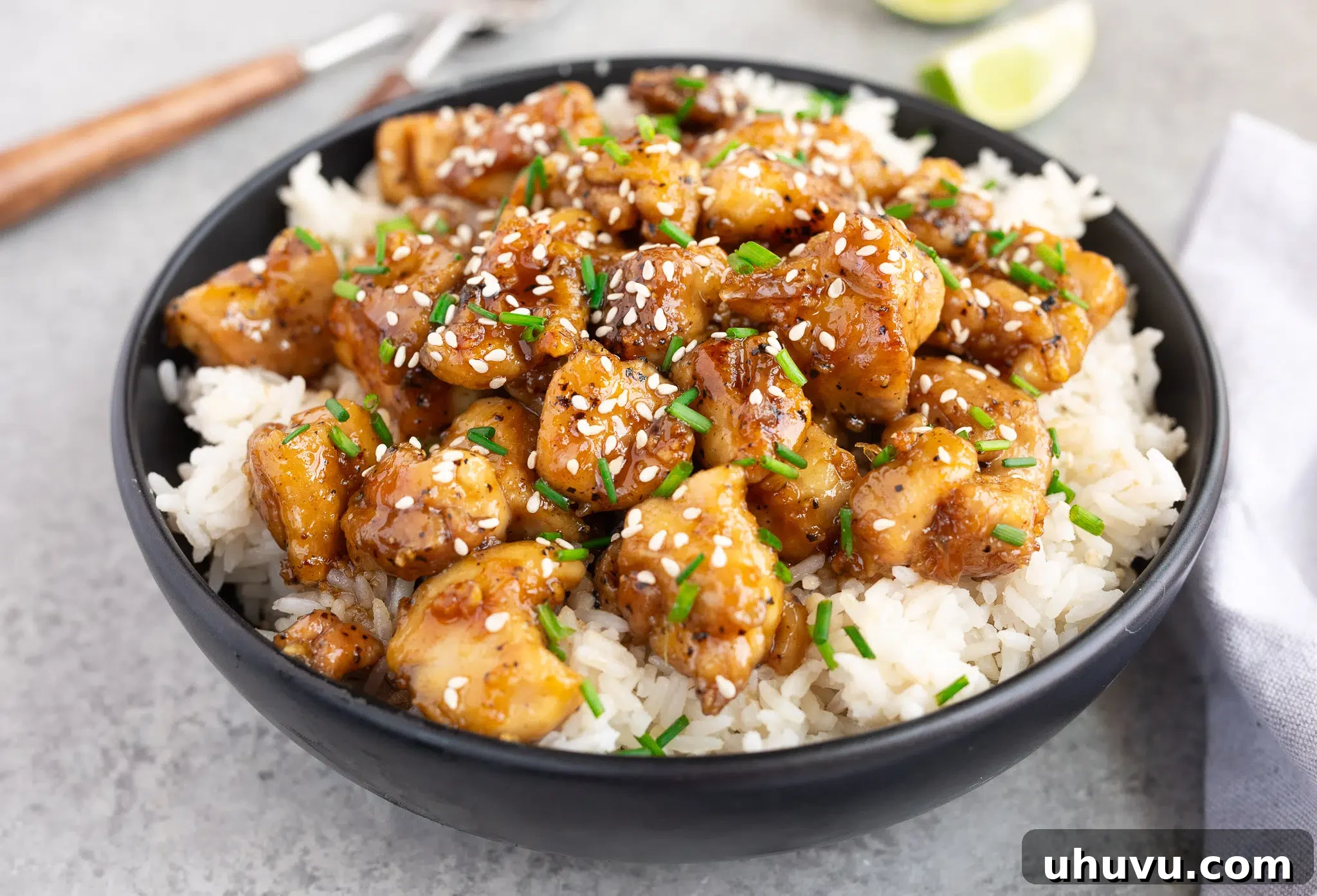 honey garlic chicken served over rice in a black bowl