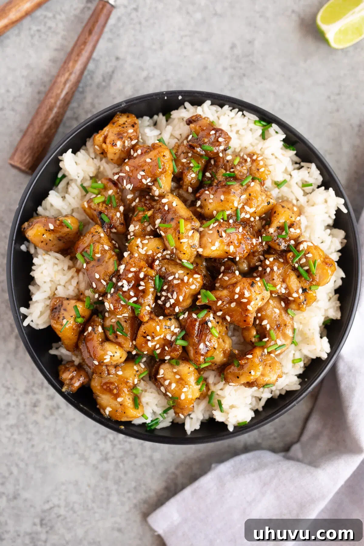 finished honey garlic chicken served in a bowl with rice and garnish