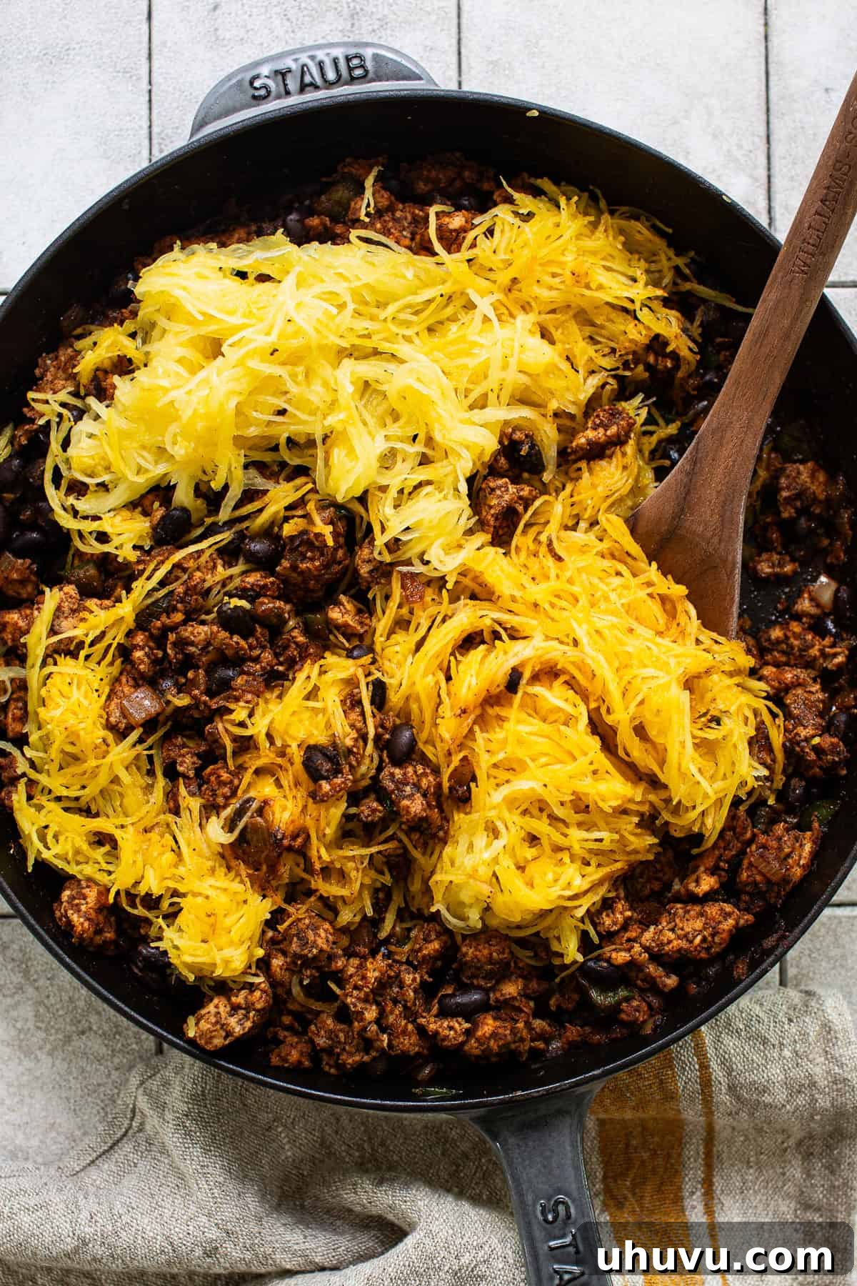 Hearty Spaghetti Squash Bake 7 Spaghetti squash noodles being mixed into the ground chicken and black bean filling.