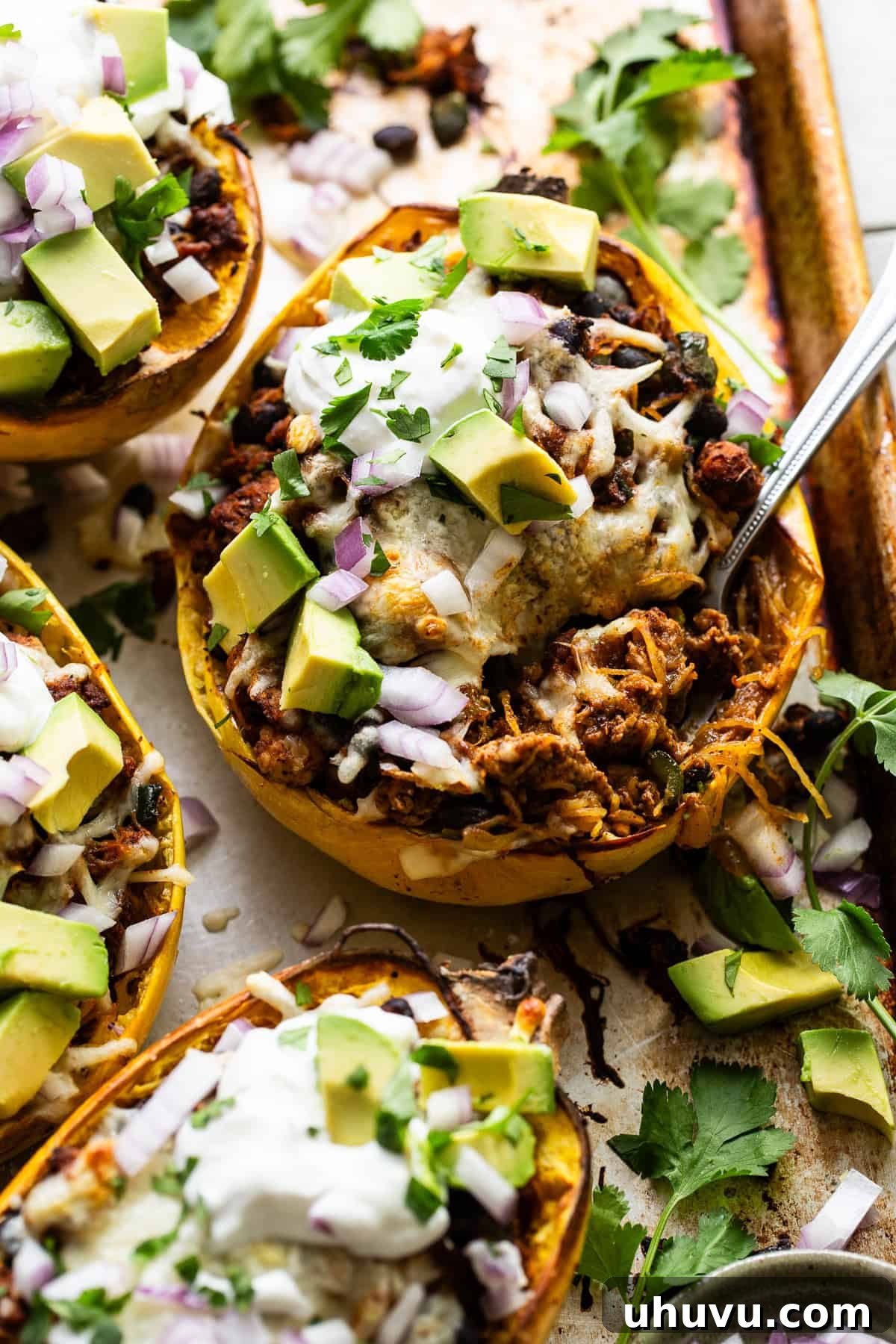 Hearty Spaghetti Squash Bake 10 Stuffed spaghetti squash with a fork being eaten.