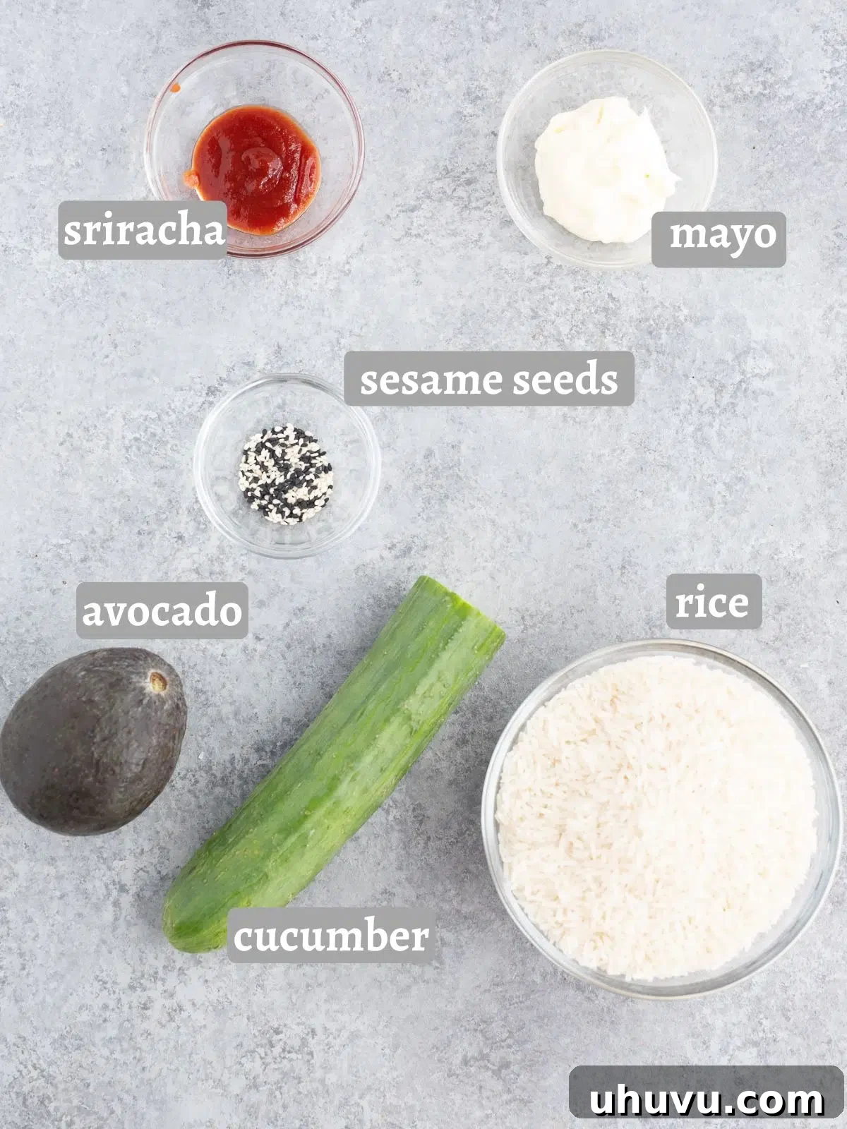 Full spread of ingredients for a salmon rice bowl: rice, cucumber, avocado, and salmon pieces.