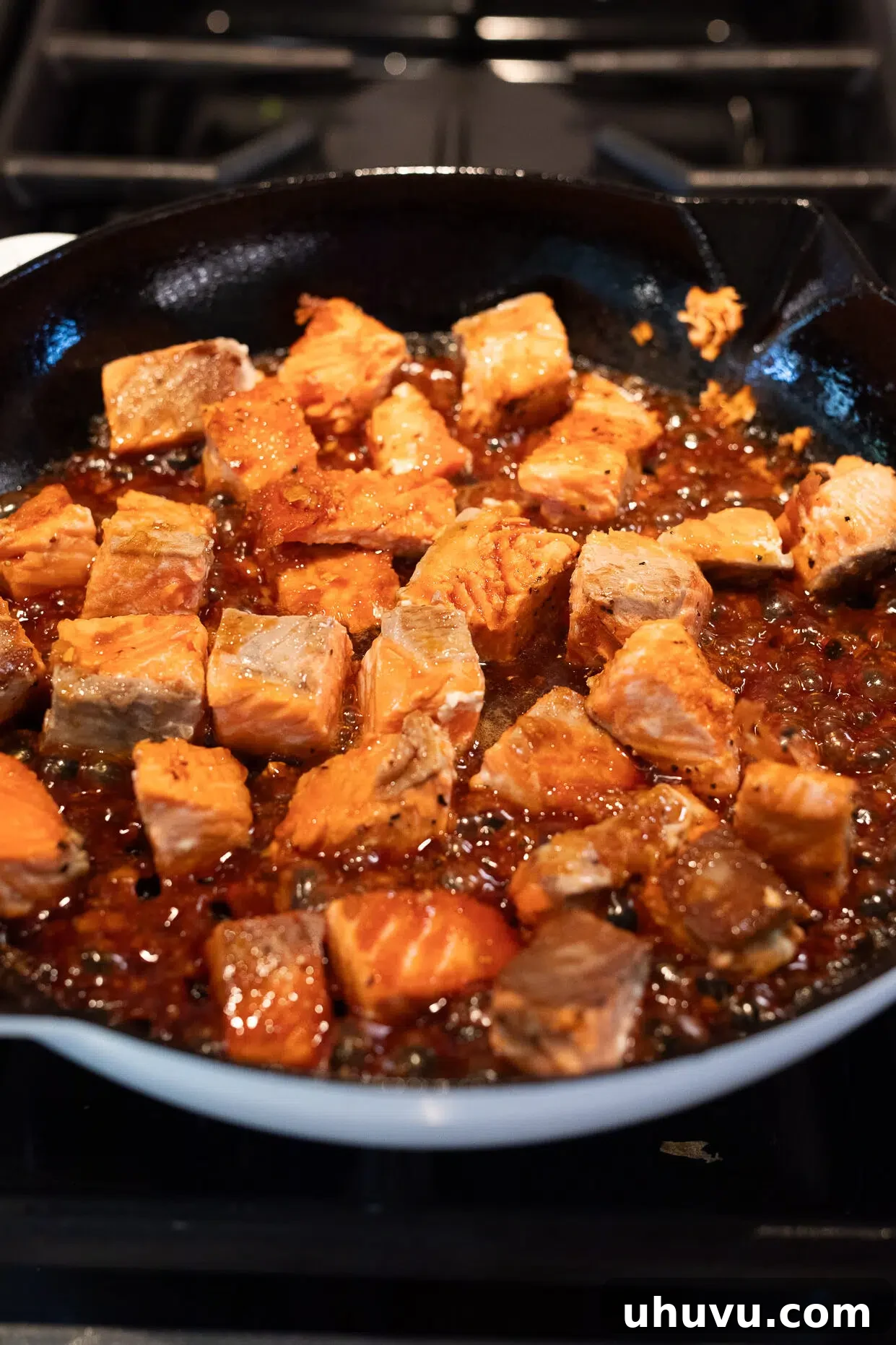 Tossing seared salmon in the thick, glossy homemade glaze.