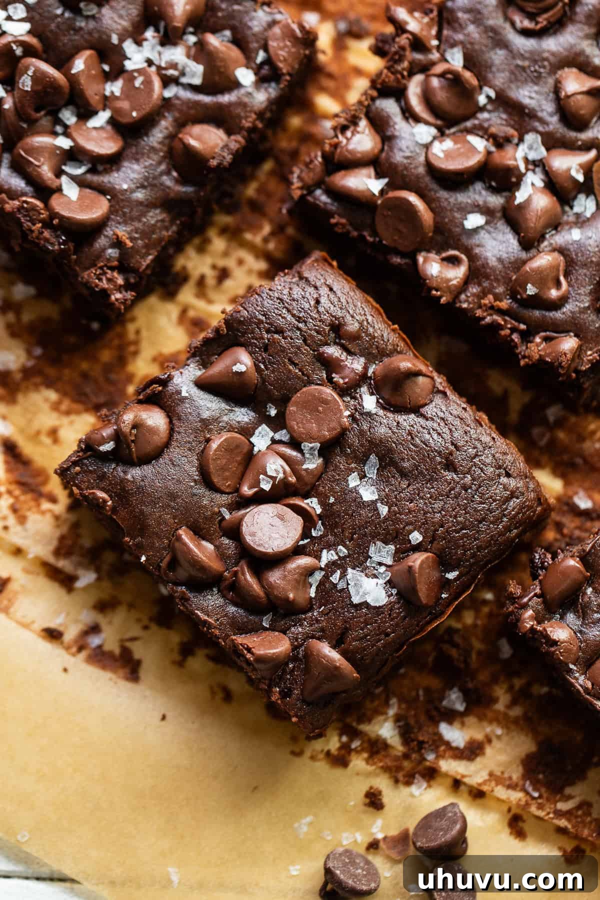 Wholesome Fudgy Black Bean Brownies 2 Black bean brownies cut into perfect squares, artfully arranged on parchment paper and sprinkled with delicate flaky sea salt for an irresistible finish.