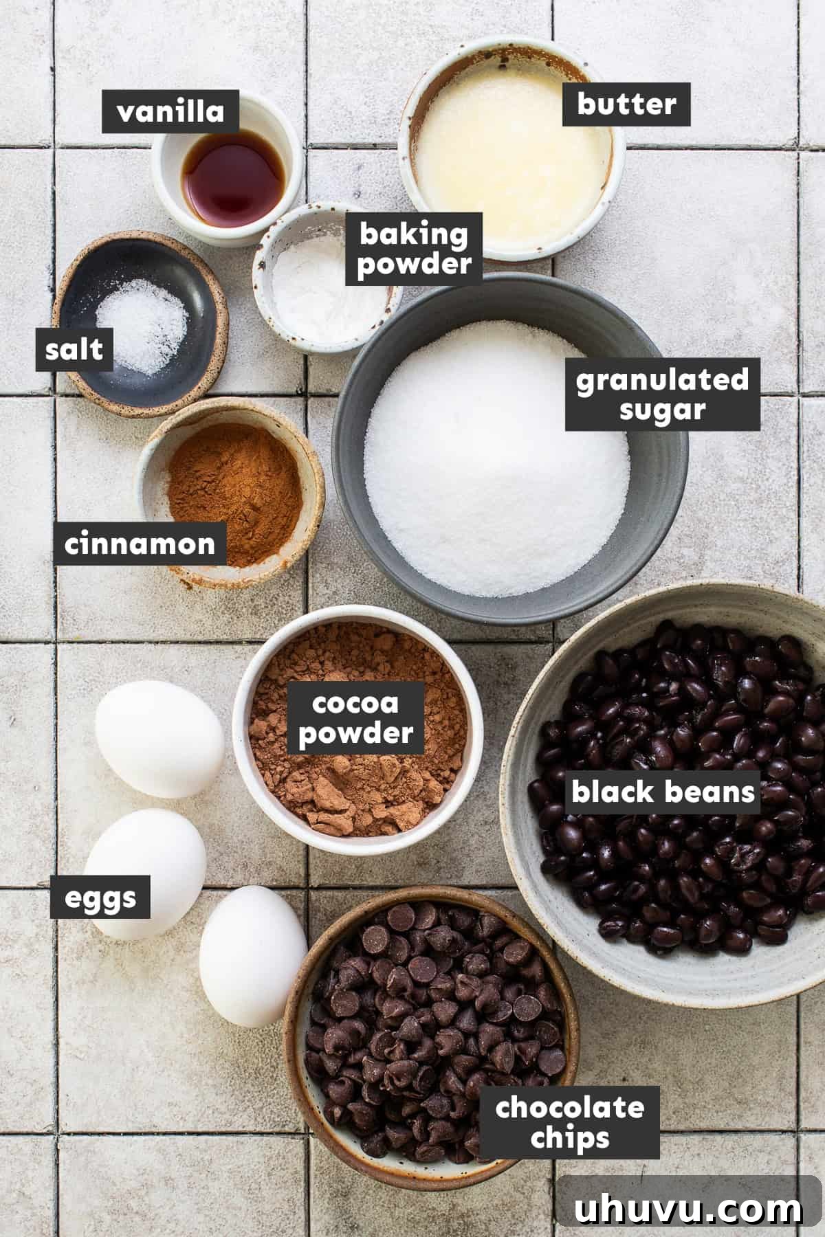 Wholesome Fudgy Black Bean Brownies 3 A vibrant flat lay shot showcasing all the fresh ingredients needed for baking black bean brownies, meticulously arranged on a rustic wooden table.