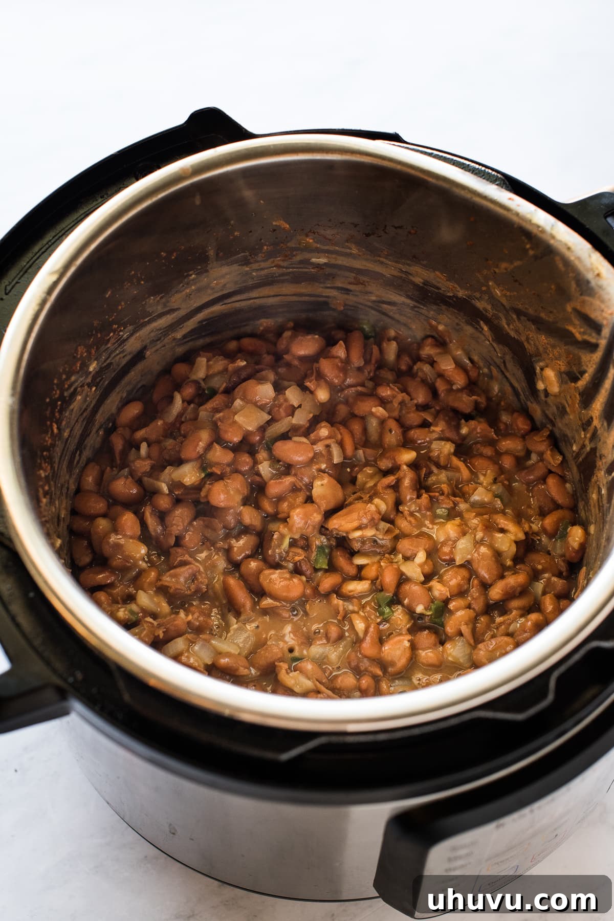 Quick and Creamy Instant Pot Refried Beans 6 Pinto beans with onions, jalapeno, and garlic in the Instant Pot