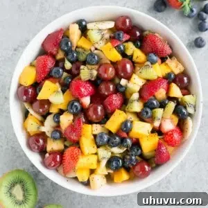 A bowl of fresh fruit salad with honey lime dressing in a recipe card format