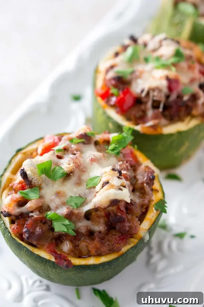 Stuffed Zucchini Cups arranged on a baking sheet before the final cheese topping