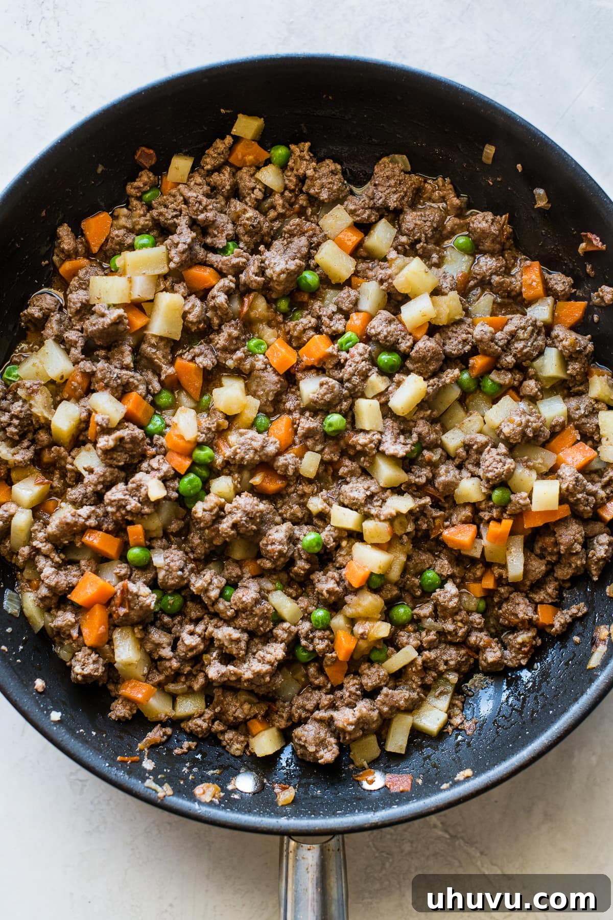 Close-up of Mexican picadillo filling with ground beef, potatoes, carrots, and peas, perfect for beef empanadas.