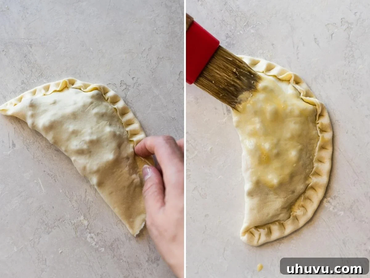 Hands carefully crimping the edges of a beef empanada dough to seal the filling inside.