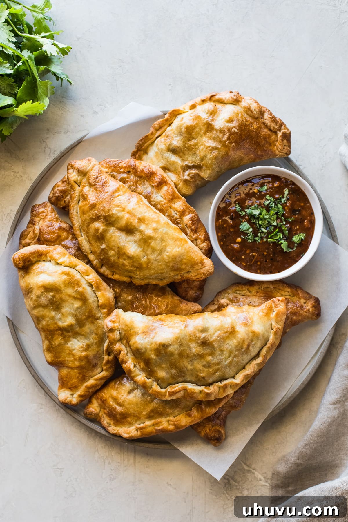 A stack of perfectly air-fried beef empanadas, showcasing their golden crust and enticing appeal.