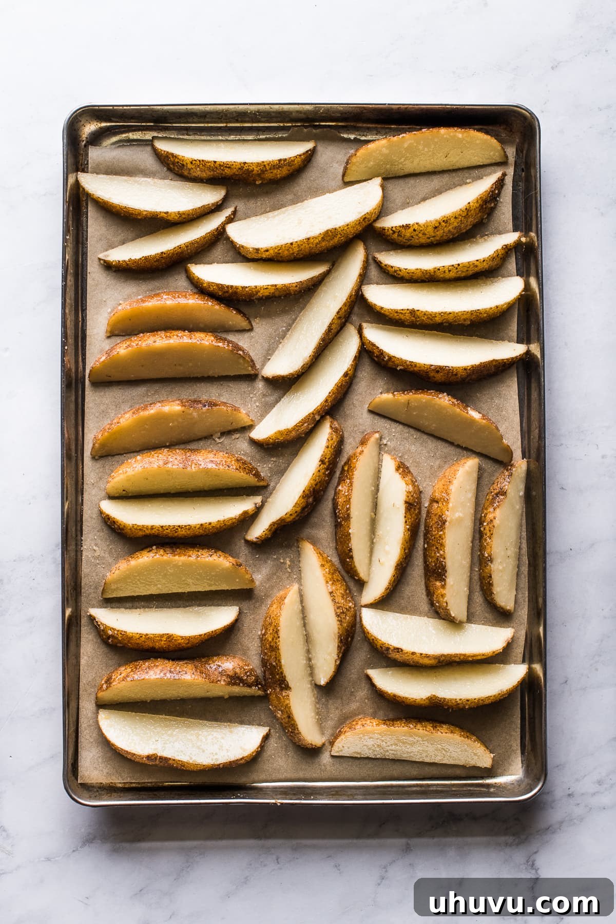Loaded Nacho Potato Wedges 4 Potato wedges on a baking sheet.