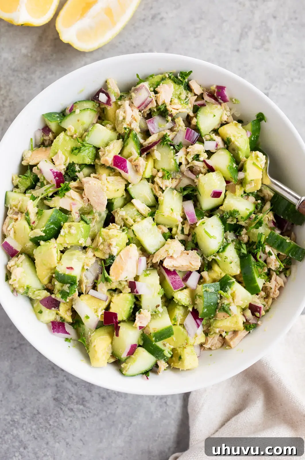 Close-up of a perfectly tossed avocado tuna salad in a bowl, showcasing the creamy avocado and fresh ingredients.