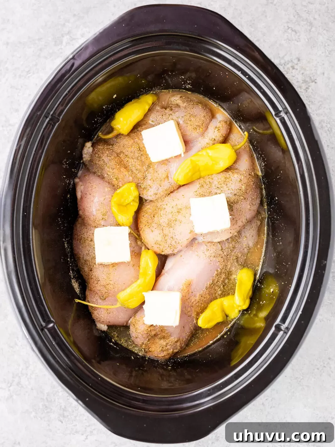 Authentic Mississippi Slow Cooker Chicken 7 cooking chicken with pepperoncini and seasonings in a slow cooker
