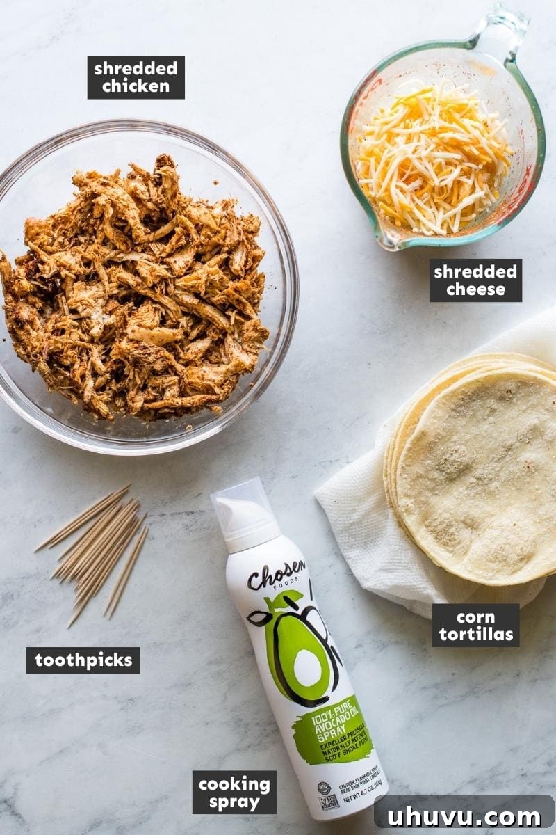 Ingredients in air fryer chicken taquitos on a table. Shredded chicken, cheese, tortillas, and spices laid out.
