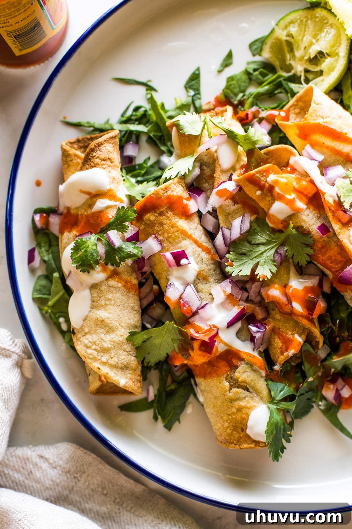 Crispy air fryer taquitos topped with Mexican toppings and ready to eat. A visually appealing, delicious meal.
