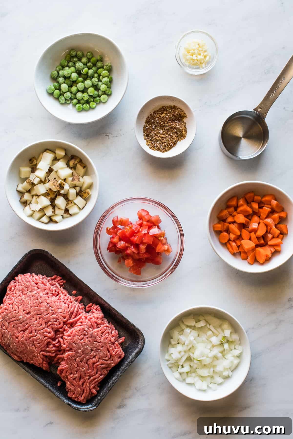 Savory Beef Pockets 4 Fresh ingredients laid out on a clean surface, including ground beef, diced vegetables, and various spices, all prepped for making beef empanada filling.