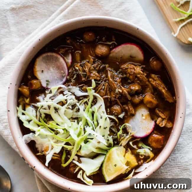 Instant Pot Pozole in a bowl garnished with radishes, shredded lettuce, and a lime.