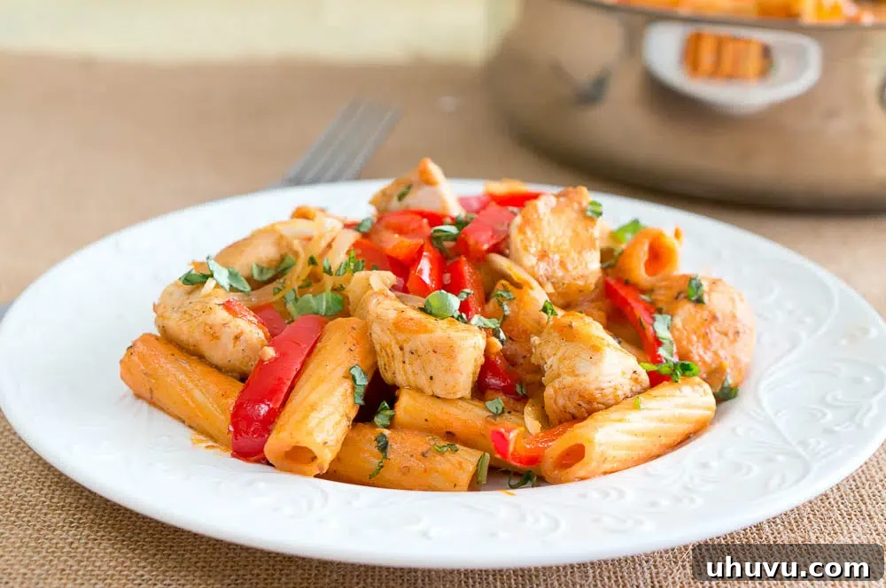 Chicken Riggies on a white patterned plate next to a fork, ready to eat