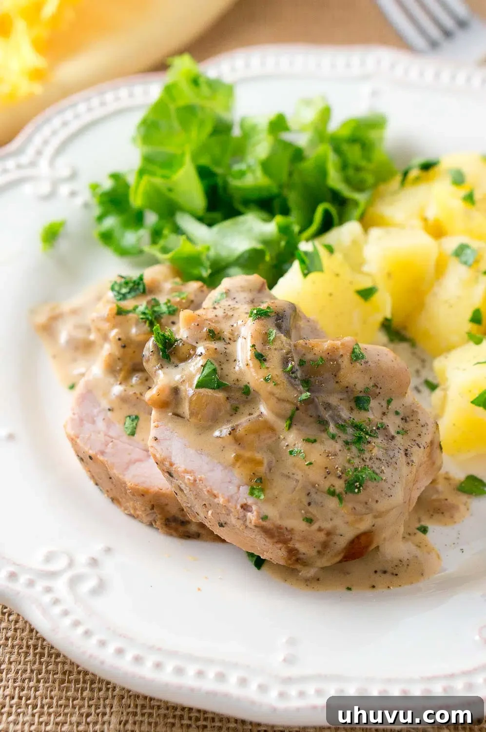 Overhead shot of pork medallions with a creamy Marsala sauce and a vibrant side dish, perfect for a hearty dinner.