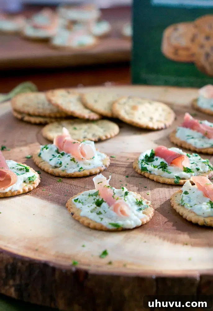 Ricotta and Prosciutto Cracker Appetizers on a platter with Back to Nature crackers in background