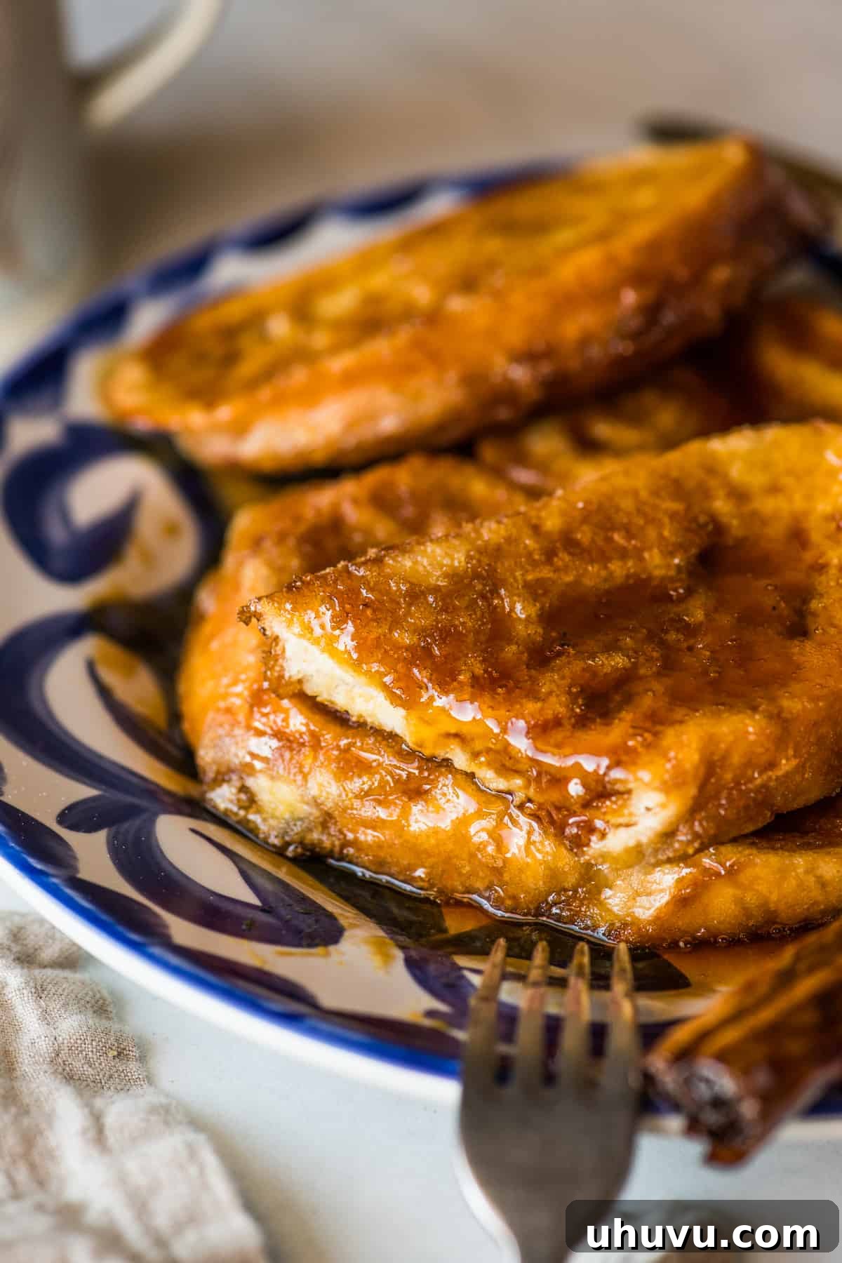 Torrejas Mexican French Toast 11 A close-up of a Torreja with a slice removed, revealing the soft, fluffy interior of the bread coated in egg.