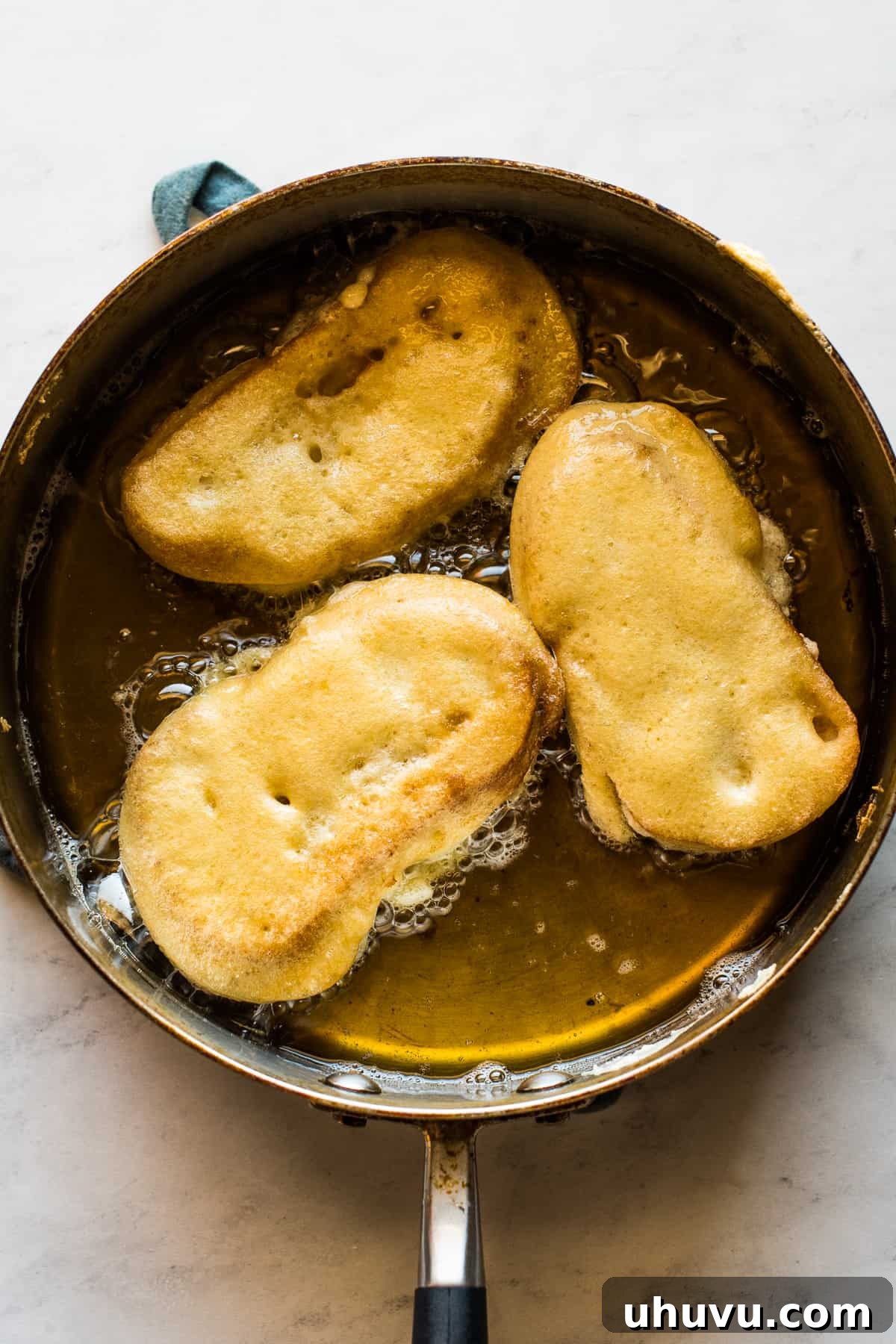 Torrejas Mexican French Toast 8 Several Torrejas frying in hot oil in a large skillet, turning golden brown and crispy.