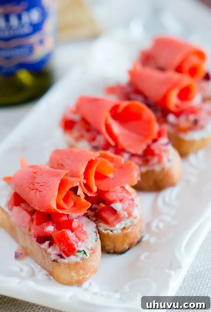Close-up of a perfectly crafted smoked salmon crostini, showcasing the vibrant colors of salmon, tomato relish, and goat cheese on toasted bread.