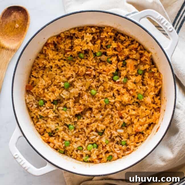 Cooked Mexican rice in a pot with peas mixed in, ready to be served.