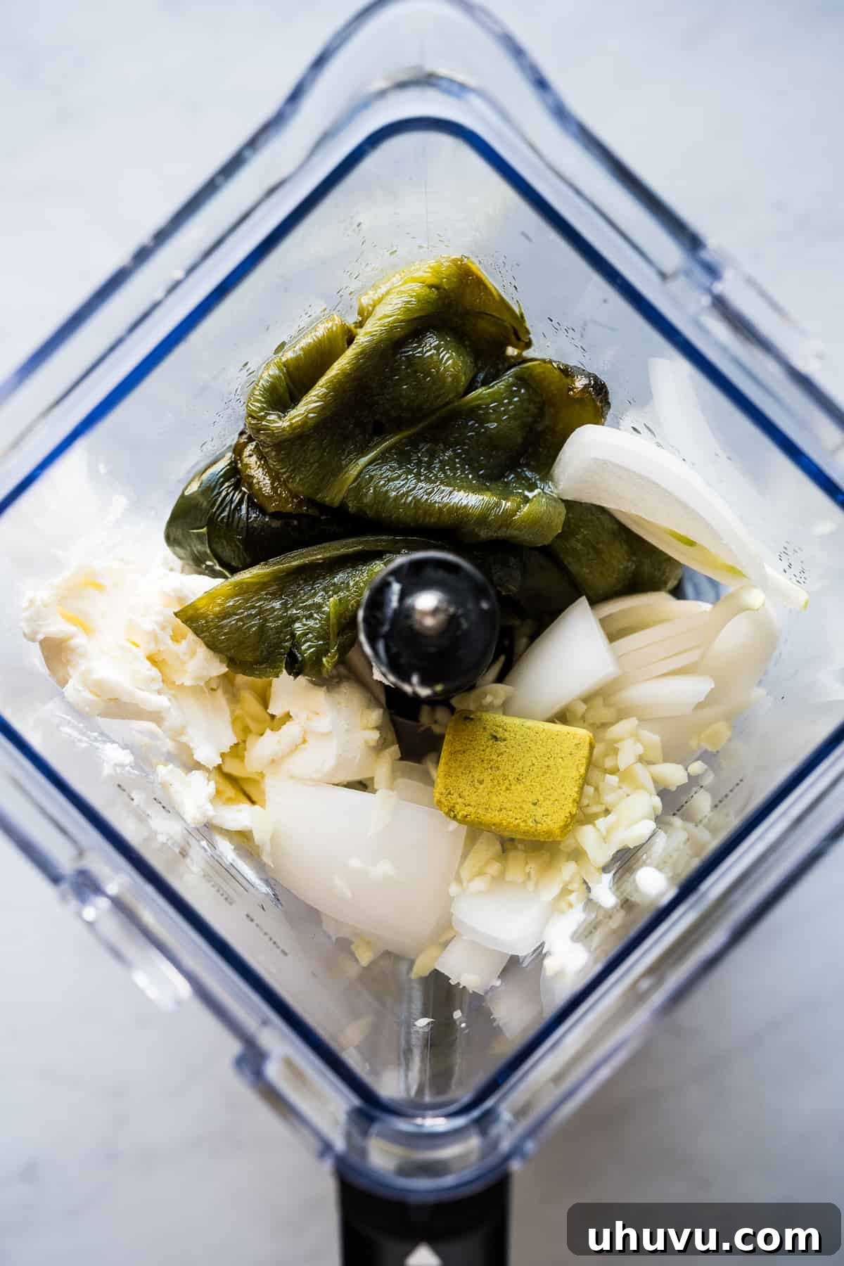 Zesty Green Spaghetti 8 All the ingredients for the creamy roasted poblano sauce – peppers, cream cheese, crema, onion, garlic, and bouillon – placed in a blender.