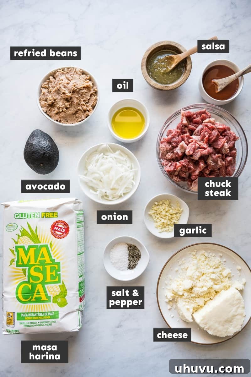 A vibrant display of fresh ingredients for the Huaraches recipe, including masa harina, onions, garlic, beef chuck steak, and various fresh produce.