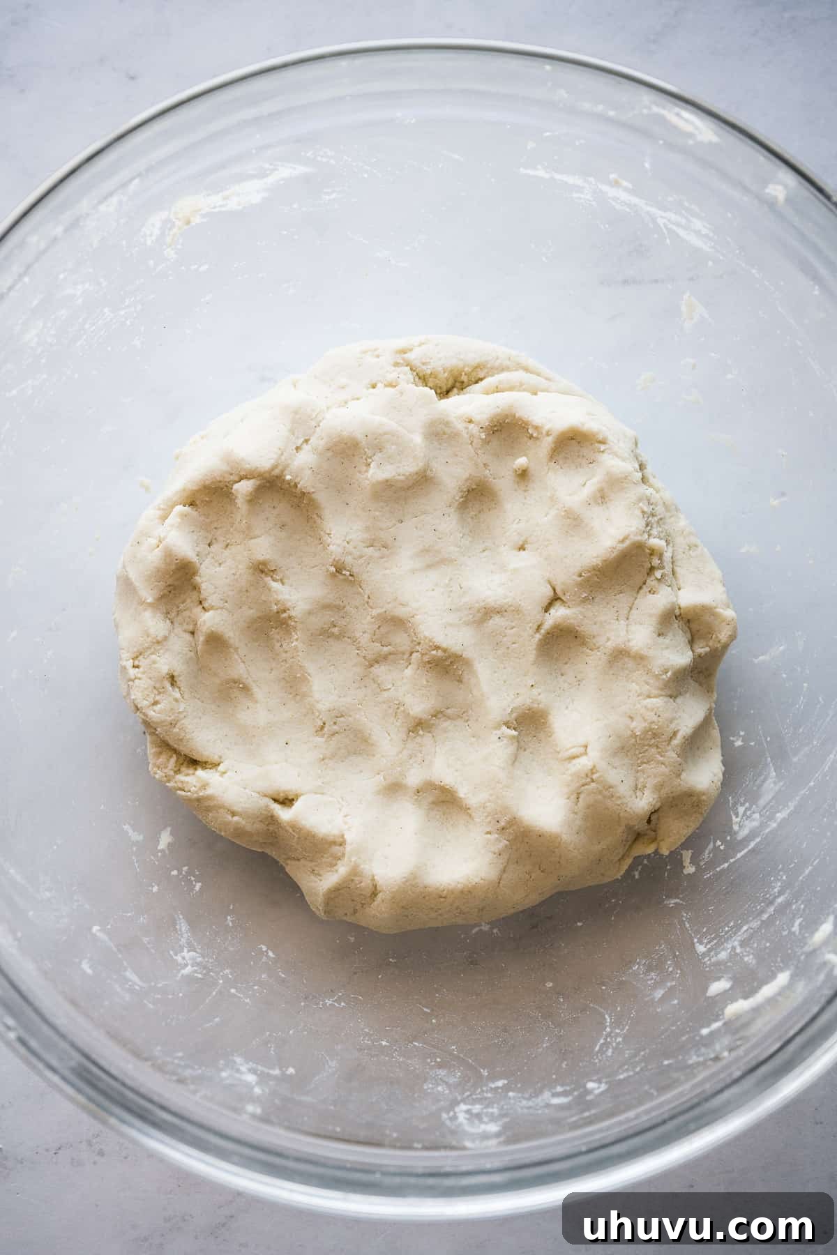 Masa dough in a clear glass bowl, showcasing its smooth and consistent texture, ready for shaping into huaraches.