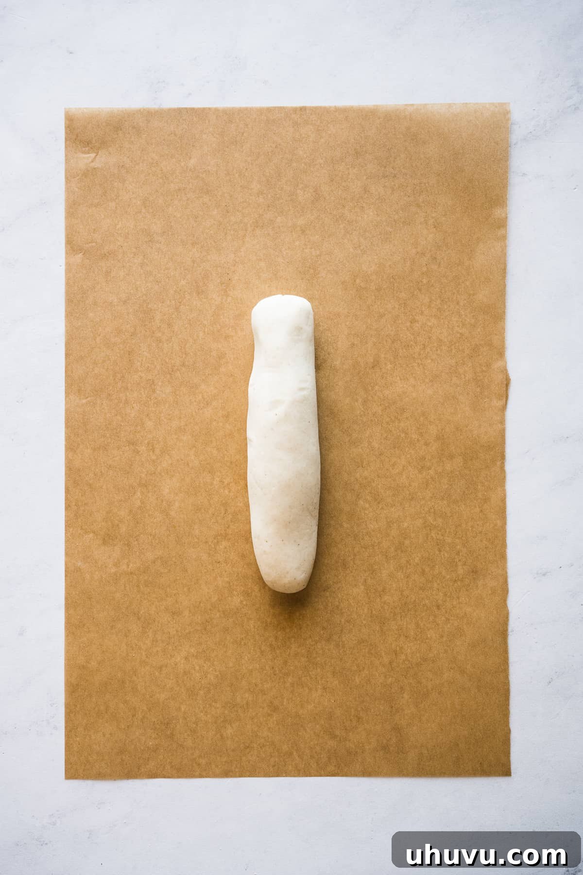 Masa dough expertly rolled into an elongated log, the initial step before flattening it into the iconic huarache shape.